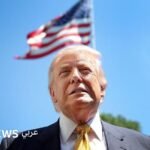 صورة للرئيس الأمريكي دونالد ترامب يتحدث في مؤتمر صحفي، مع خلفية تظهر أعلام الولايات المتحدة.