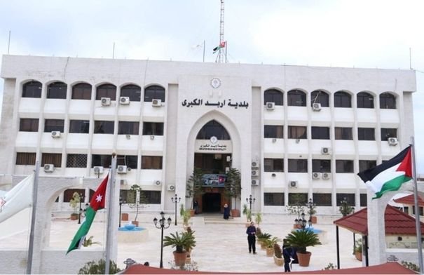 عمال يقومون بأعمال تعبيد الطرق في شارع فوزي الملقي بإربد