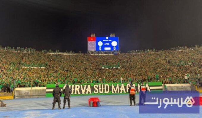 صورة تظهر جماهير الرجاء الرياضي في مدرجات "كورفا سود" ترفع لافتات دعم للفريق والمعتقلين.