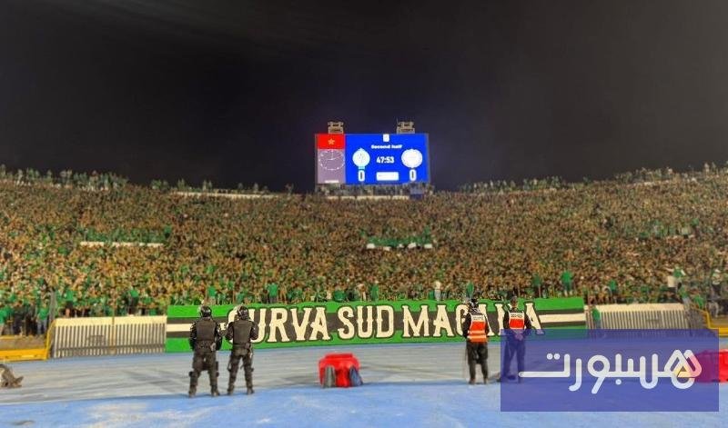 صورة تظهر جماهير الرجاء الرياضي في مدرجات "كورفا سود" ترفع لافتات دعم للفريق والمعتقلين.