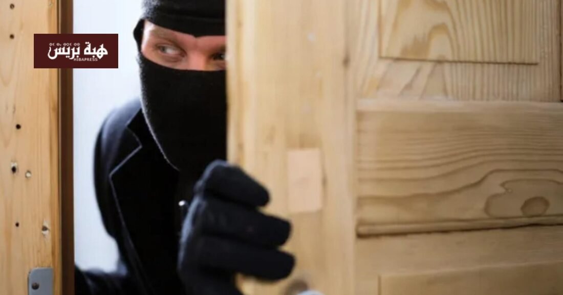 صورة من كاميرات المراقبة تظهر لصاً يحاول فتح باب أمني في سكن طلابي.