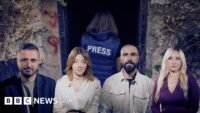 صورة لصحفيين يرتدون سترات واقية تحمل كلمة 'PRESS' وخوذات في منطقة نزاع بجنوب لبنان.