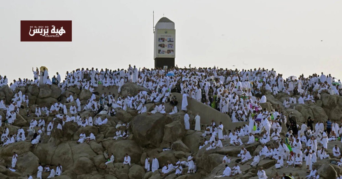 صورة جوية تظهر جموع الحجاج بلباس الإحرام الأبيض يتدفقون من صعيد عرفات إلى مشعر مزدلفة في الليل، مع إضاءة المسارات.