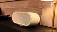 La Denon Home 600, une enceinte connectée de couleur grise, posée sur une surface, mettant en avant son design sobre et sa large grille frontale.