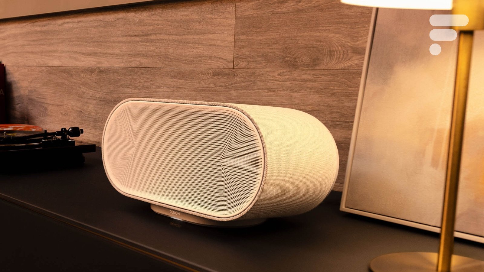 La Denon Home 600, une enceinte connectée de couleur grise, posée sur une surface, mettant en avant son design sobre et sa large grille frontale.