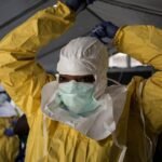 Une professionnelle de santé en tenue de protection intégrale devant un centre de traitement Ebola à Beni, en RDC, en août 2018.