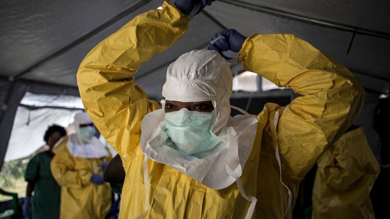 Une professionnelle de santé en tenue de protection intégrale devant un centre de traitement Ebola à Beni, en RDC, en août 2018.