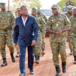 Le président Faure Gnassingbé lors d'une cérémonie militaire à Tchamonga, entouré de soldats et d'une foule en liesse.