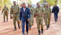 Le président Faure Gnassingbé lors d'une cérémonie militaire à Tchamonga, entouré de soldats et d'une foule en liesse.