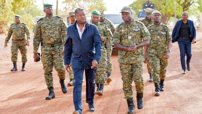 Le président Faure Gnassingbé lors d'une cérémonie militaire à Tchamonga, entouré de soldats et d'une foule en liesse.