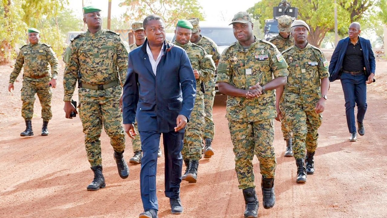 Le président Faure Gnassingbé lors d'une cérémonie militaire à Tchamonga, entouré de soldats et d'une foule en liesse.