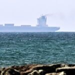 Vessels off the coast of Sharjah, UAE, symbolizing global oil trade and supply routes.