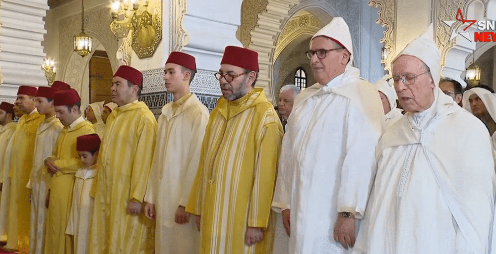 Sa Majesté le Roi Mohammed VI accomplissant la prière de l'Aïd Al-Adha à la mosquée "Ahl Fès" à Rabat, entouré de membres de la famille royale.