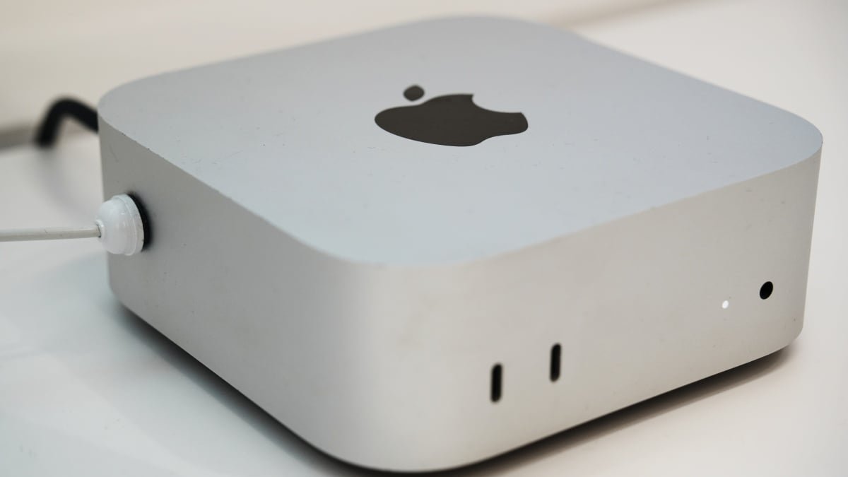 A sleek, compact Apple Mac Mini desktop computer, representing the latest model with enhanced AI capabilities.