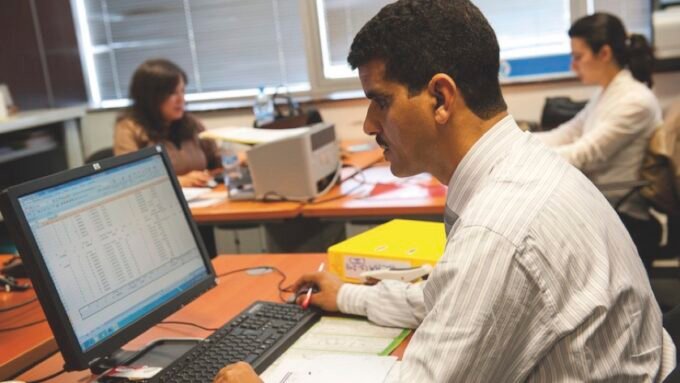 Une image symbolisant le marché du travail marocain, avec des silhouettes de travailleurs et des graphiques économiques en arrière-plan.