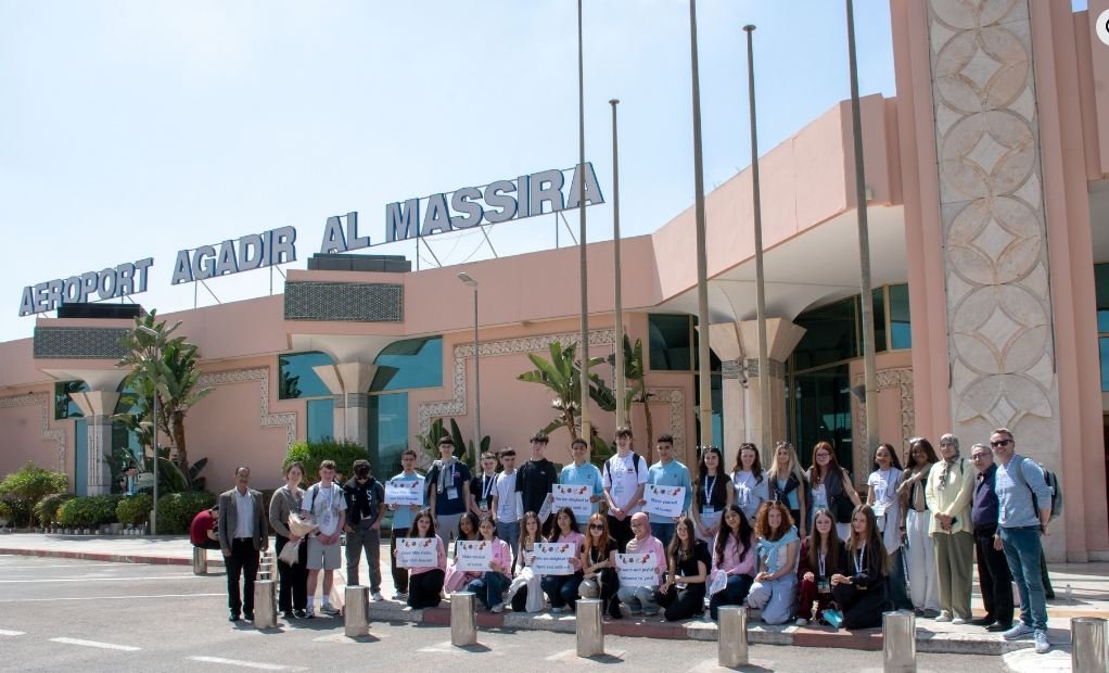 Des élèves marocains et irlandais souriants participant à un atelier culinaire, symbole de l'échange culturel et de l'amitié entre les deux nations.