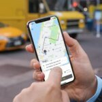 Illustration d'un smartphone affichant une application de transport avec un taxi en arrière-plan, symbolisant la régulation et la modernisation du secteur au Maroc.