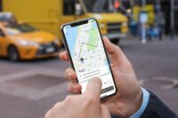 Illustration d'un smartphone affichant une application de transport avec un taxi en arrière-plan, symbolisant la régulation et la modernisation du secteur au Maroc.