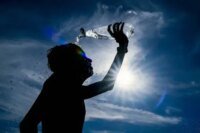Une personne se protégeant du soleil intense au Maroc, illustrant les défis de la canicule et l'importance des précautions.