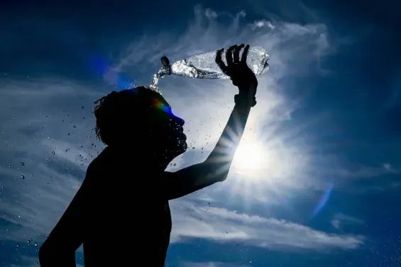 Une personne se protégeant du soleil intense au Maroc, illustrant les défis de la canicule et l'importance des précautions.