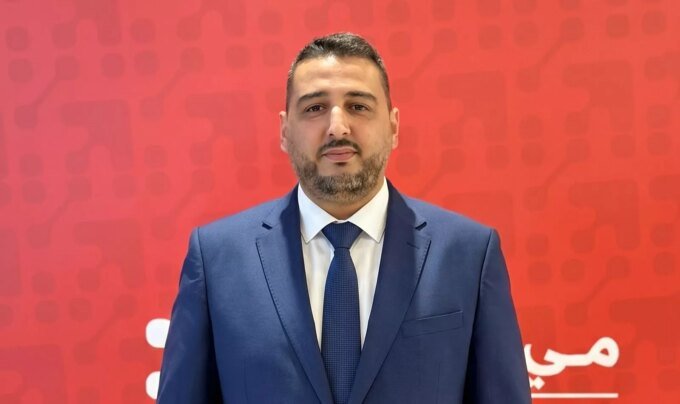 Ahmed Chafak, directeur général de Maymouna Services Financiers, annonçant le lancement de MayCash, avec un logo ou un visuel de la marque en arrière-plan, symbolisant l'expansion du réseau de proximité.