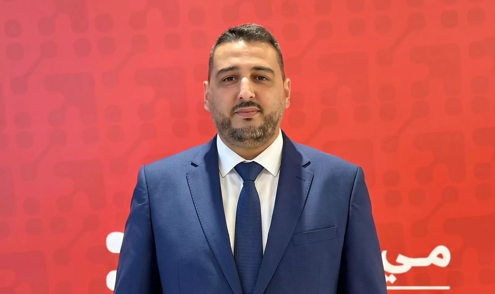 Ahmed Chafak, directeur général de Maymouna Services Financiers, annonçant le lancement de MayCash, avec un logo ou un visuel de la marque en arrière-plan, symbolisant l'expansion du réseau de proximité.