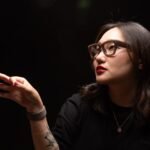 A person wearing Meta Ray-Ban Display smart glasses, interacting with virtual elements in their field of vision.