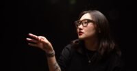 A person wearing Meta Ray-Ban Display smart glasses, interacting with virtual elements in their field of vision.