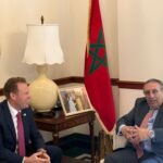 Drapeaux du Maroc et des États-Unis flottant côte à côte, symbolisant la coopération pour la Coupe du Monde de la FIFA.