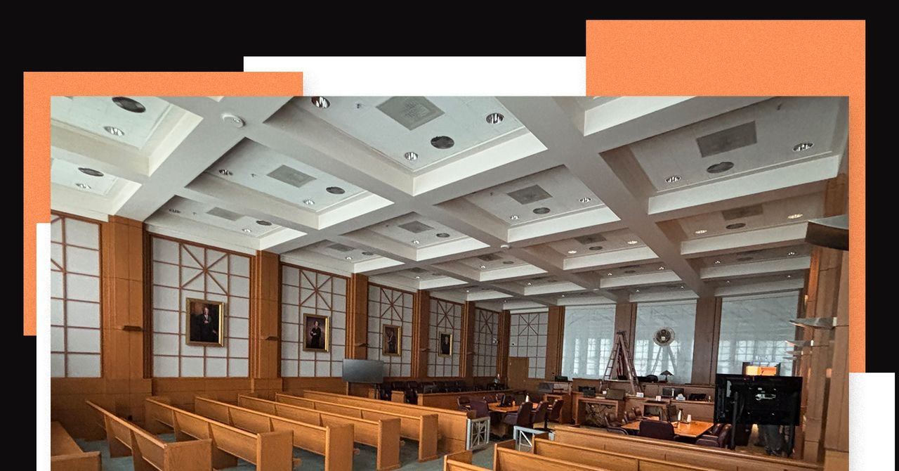 Various luxury seat cushions on hard wooden benches in a courtroom, with legal documents and water bottles nearby.