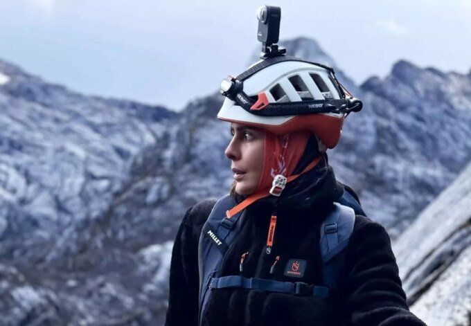 Nawal Sfendla : La Pionnière Marocaine Conquiert Everest et Lhotse, un Double Exploit Historique 6 Nawal Sfendla, alpiniste marocaine, souriante et équipée pour l'alpinisme, avec un paysage montagneux en arrière-plan, symbolisant sa détermination et son exploit sur l'Everest et le Lhotse.