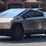 A Tesla Cybertruck on a road with one of its wheels highlighted, symbolizing the recall issue.
