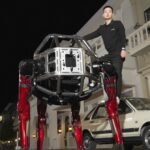The Unitree GD01 giant mecha robot in its red and black design, possibly smashing a wall or in a crabwalk position.