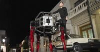The Unitree GD01 giant mecha robot in its red and black design, possibly smashing a wall or in a crabwalk position.
