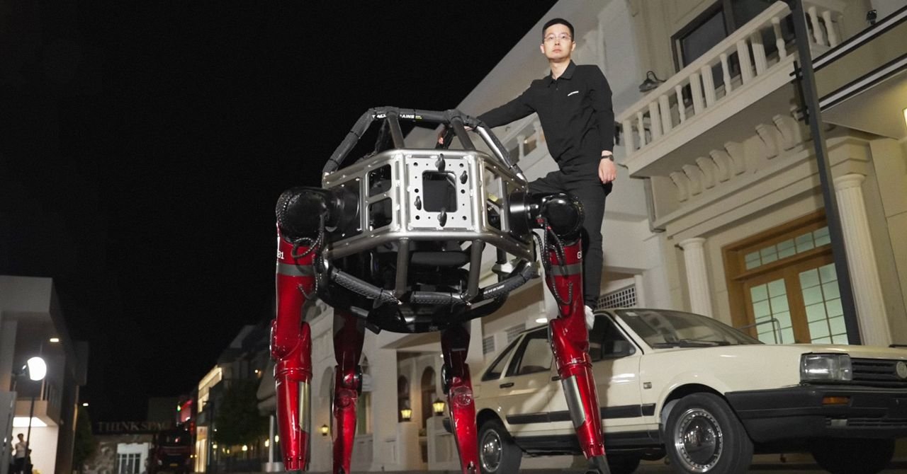 The Unitree GD01 giant mecha robot in its red and black design, possibly smashing a wall or in a crabwalk position.