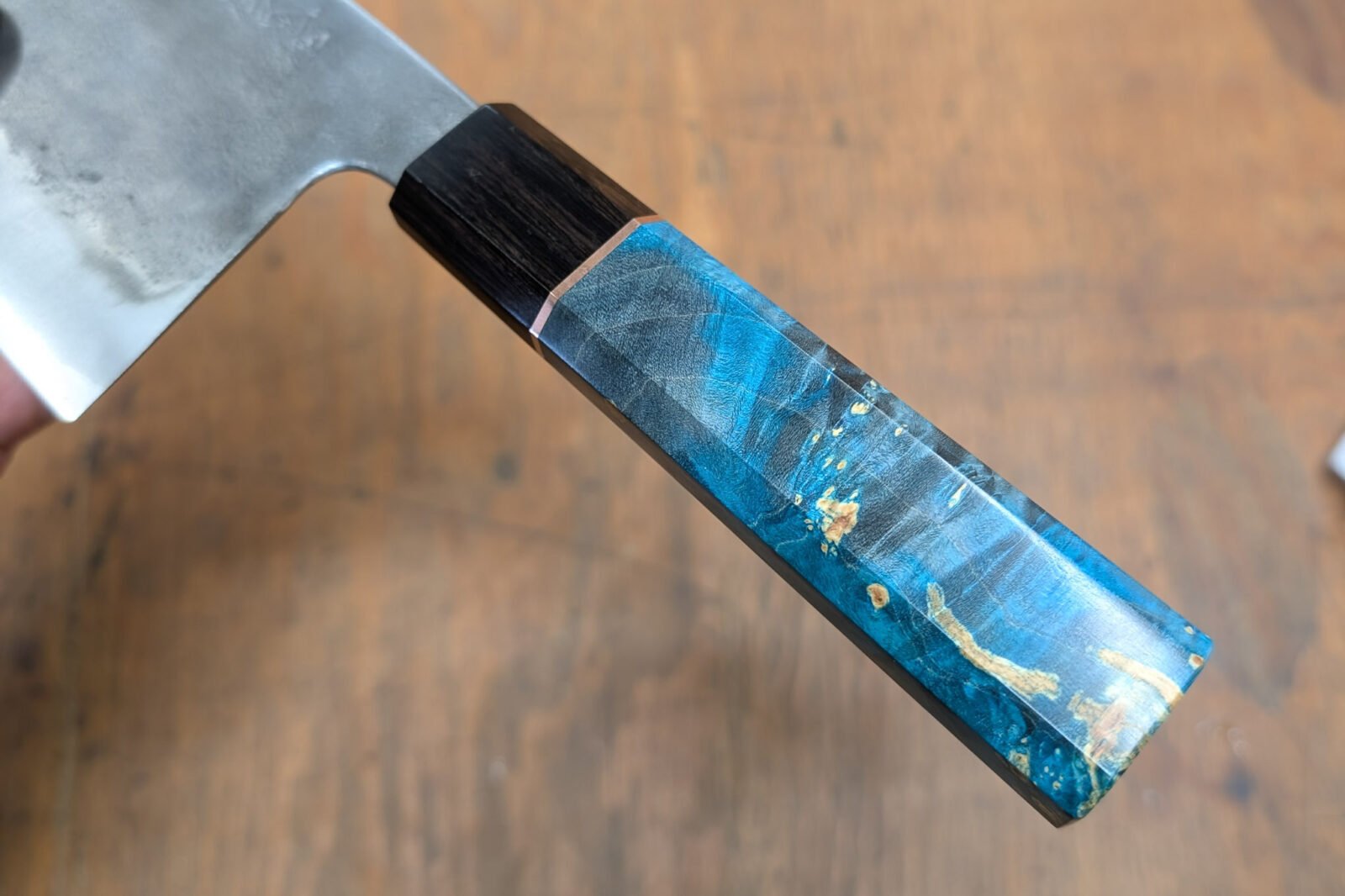 A beautifully crafted Wa-style octagonal knife handle made from two contrasting woods, showcasing the intricate joinery and smooth finish.