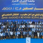 Mohamed Chaouki, président du RNI, s'exprimant devant une assemblée de jeunes lors de l'Université d'été de la jeunesse RNI à Agadir, avec un public attentif en arrière-plan.