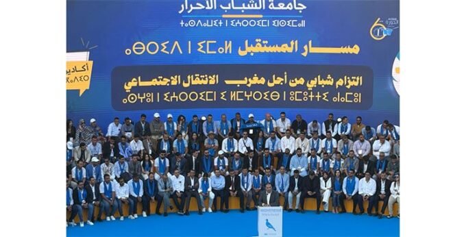 Mohamed Chaouki, président du RNI, s'exprimant devant une assemblée de jeunes lors de l'Université d'été de la jeunesse RNI à Agadir, avec un public attentif en arrière-plan.