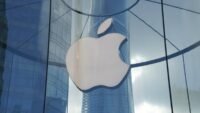 A pair of sleek, futuristic smart glasses with an Apple logo, symbolizing the delayed augmented reality device.