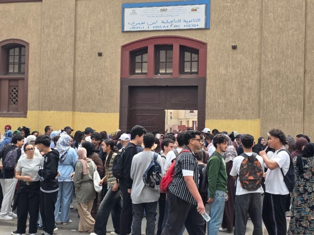 Des lycéens sortant d'un centre d'examen du Baccalauréat 2026 à Casablanca, avec des parents attendant à l'extérieur.