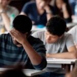 Des lycéens révisant ensemble avec des livres et des cahiers, symbolisant l'effort et le soutien scolaire pour le baccalauréat.