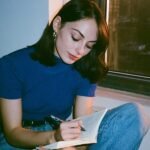 Beyond Consumption: How 'Thinking on Paper' Unlocks Superior Clarity 8 A hand writing notes in a notebook with a pen, symbolizing clear thinking and information processing.