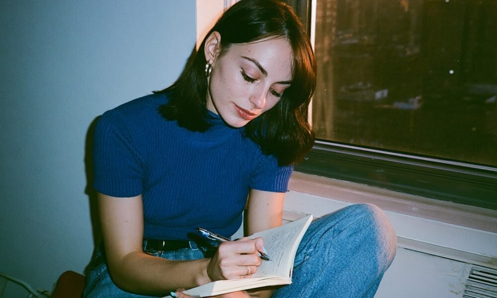 A hand writing notes in a notebook with a pen, symbolizing clear thinking and information processing.