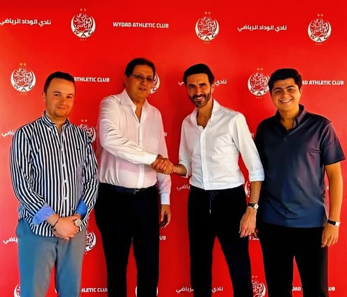 صورة لألكسندر رويز يتحدث في برنامج رياضي مع شعار كأس أمم إفريقيا في الخلفية