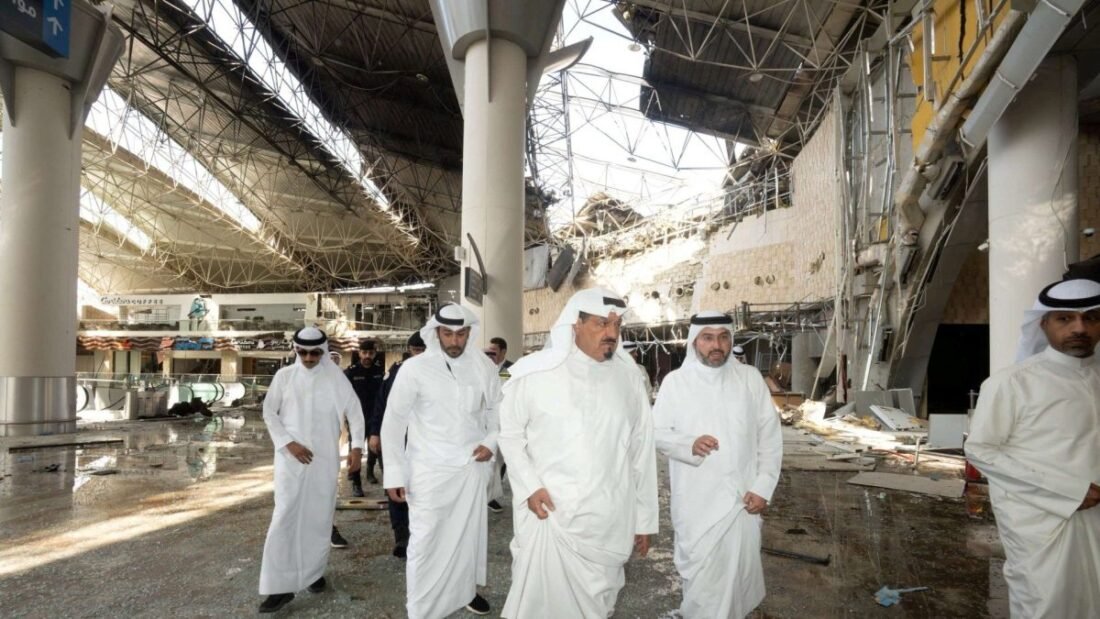 مسؤولون كويتيون يتفقدون الأضرار في إحدى صالات مطار الكويت الدولي بعد هجوم بطائرات مسيرة وصواريخ.