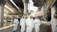 مسؤولون كويتيون يتفقدون الأضرار في إحدى صالات مطار الكويت الدولي بعد هجوم بطائرات مسيرة وصواريخ.