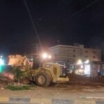 عمال بلدية إربد يزيلون الأتربة والأشجار من دوار ميدان الثقافة تمهيداً لتركيب إشارة ضوئية ذكية.
