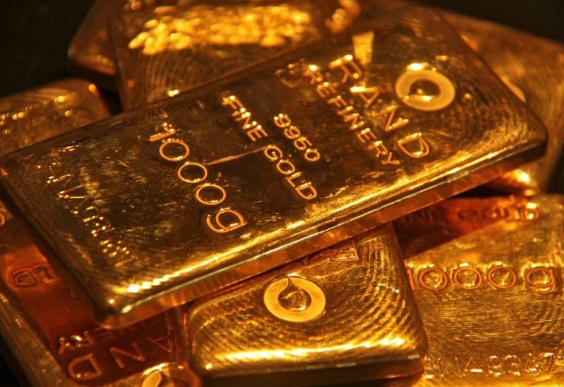 صورة لسبائك ذهبية متراكمة مع خلفية لسوق المال، تعكس تراجع أسعار الذهب العالمية.