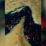 صورة لمضيق هرمز مع سفن تجارية تعبره، ترمز لعودة الملاحة بعد الاتفاق.