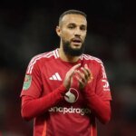 صورة لنصير مزراوي بقميص المنتخب المغربي، مع شعار كأس العالم 2026 في الخلفية.